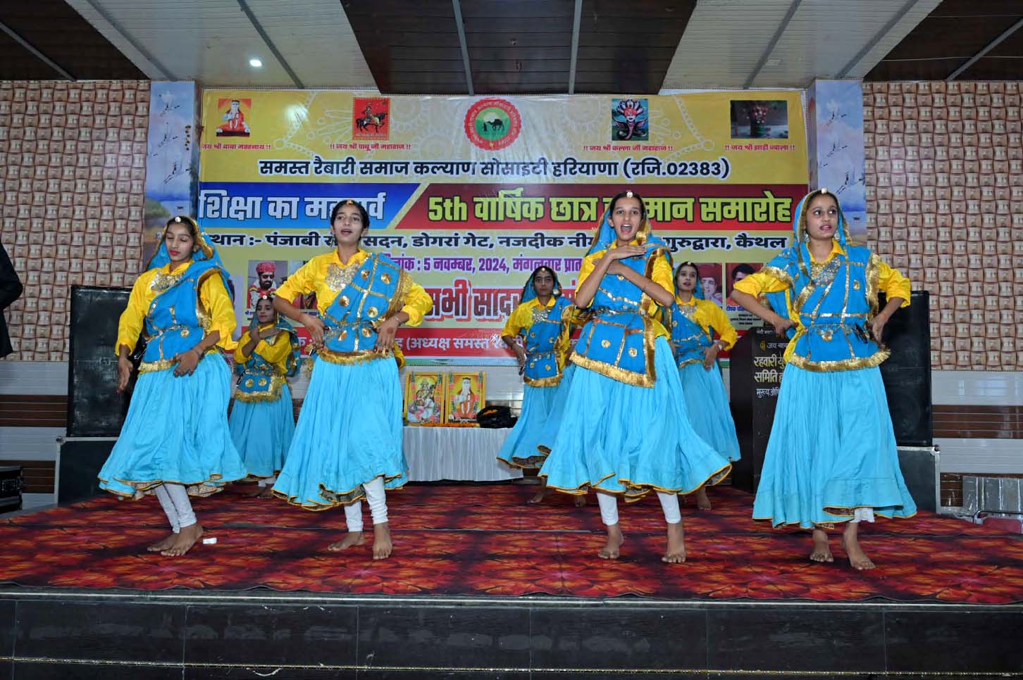 Young performers presenting a traditional group dance in blue and yellow costumes