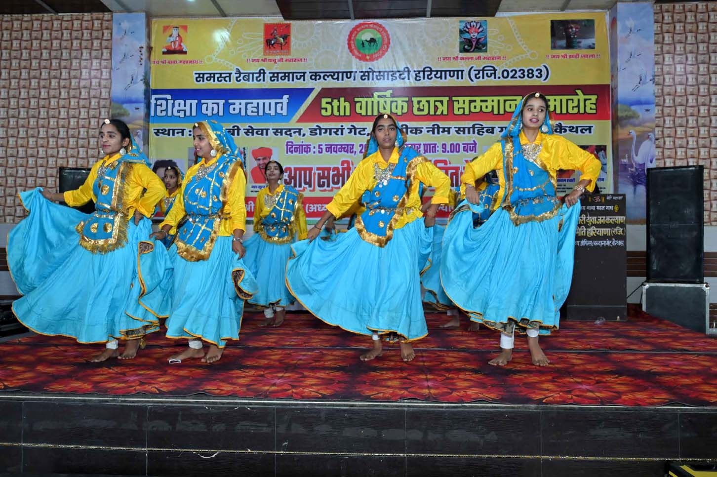 A group of performers dancing on stage in colourful traditional dresses